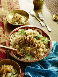 High angle view of serving dish with jeera chicken and rice with coriander garnish - ISF10410