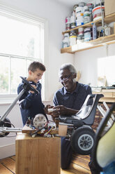 Großvater und Enkel bauen in der Garage ein Go-Kart zusammen - CAIF20690