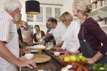 Aktive Seniorenfreunde beobachten Koch beim Pizzakochkurs - CAIF20708
