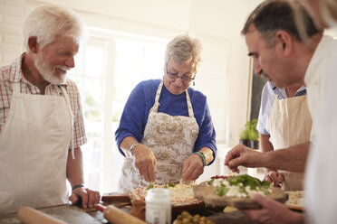 Active senior friends making pizza in cooking class - CAIF20709