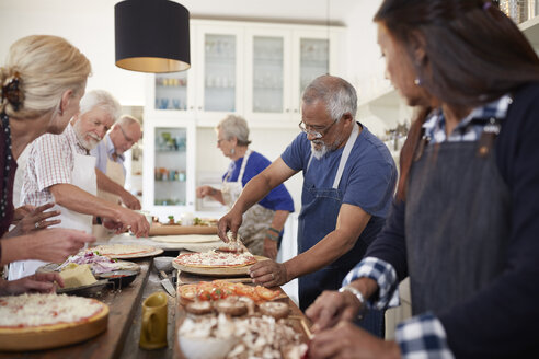 Ältere Freunde backen Pizzen im Kochkurs - CAIF20714