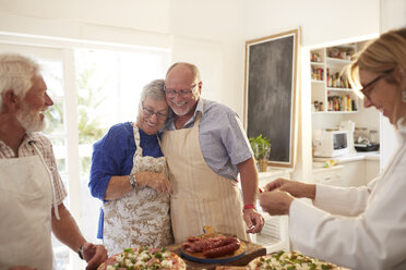 Affectionate senior couple enjoying pizza cooking class - CAIF20739