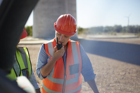 Female worker using walkie-talkie at power plant - CAIF20745