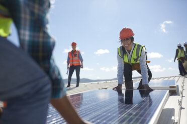 Ingenieure heben Solarmodul in sonnigem Kraftwerk - CAIF20765