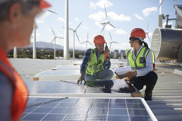 Ingenieure prüfen Solarpaneele in einem alternativen Energiekraftwerk - CAIF20800