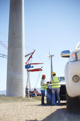 Engineers meeting at truck at sunny wind turbine power plant - CAIF20809