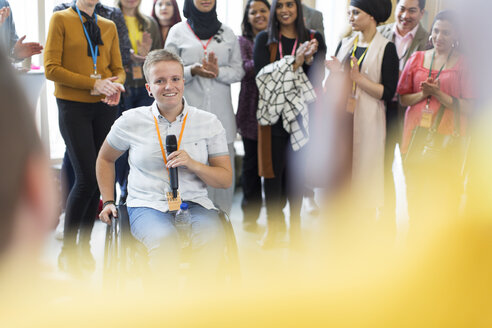 Das Publikum klatscht für eine Sprecherin im Rollstuhl - CAIF20815