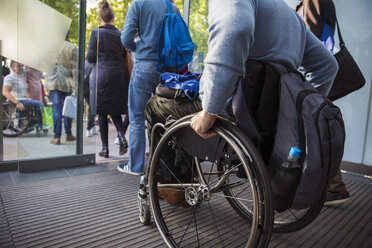 Mann im Rollstuhl verlässt Büro - CAIF20818