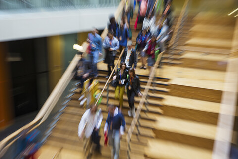 Unscharfe Bewegung Menschen absteigend Holztreppe, lizenzfreies Stockfoto