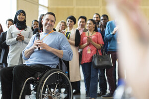 Publikum klatscht für männlichen Sprecher im Rollstuhl - CAIF20898