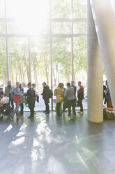 Geschäftsleute beim Networking auf einer Konferenz, Gespräche in der sonnigen Lobby - CAIF20908