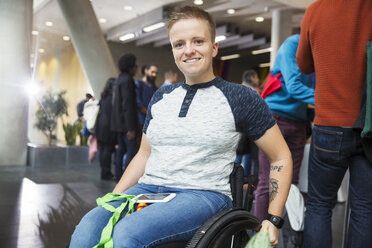 Portrait smiling young woman in wheelchair at conference - CAIF20913