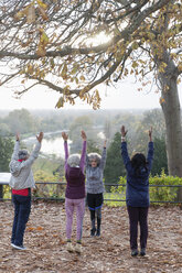 Aktive Senioren praktizieren Yoga und dehnen sich im Herbstpark - CAIF20933