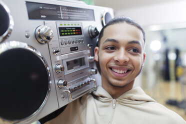 Close up portrait smiling, confident, cool teenage boy with boom box - CAIF20947