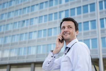 Smiling businessman on cell phone in the city - DIGF04659