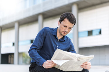 Businessman reading newspaper in the city - DIGF04661