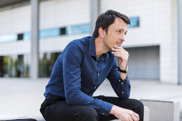 Businessman sitting outdoors thinking - DIGF04666