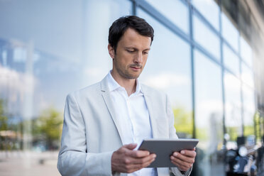 Businessman using tablet in the city - DIGF04698