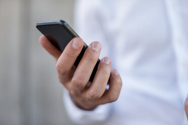 Close-up of businessman holding cell phone - DIGF04705