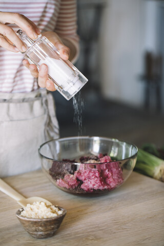 Zubereitung von Rote-Bete-Ravioli mit Salbei und Butter, Salzen der Füllung in einer Schüssel, lizenzfreies Stockfoto
