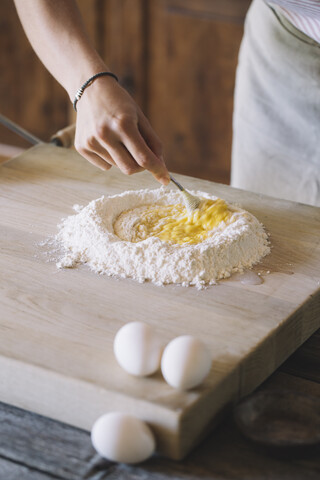 Frau bereitet Nudelteig, Mehl und Eier vor, lizenzfreies Stockfoto