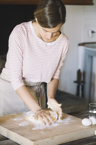 Frau bereitet Teig, Mehl und Eier vor, lizenzfreies Stockfoto