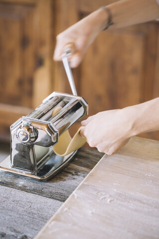 Woman preparing homemade pasta, using pasta maker stock photo