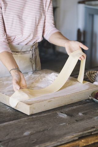 Woman preparing homemade pasta, taking dough stock photo