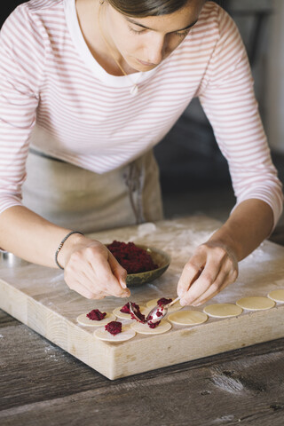 Frau bei der Zubereitung von Ravioli mit Rote-Bete-Salbei-Füllung, lizenzfreies Stockfoto