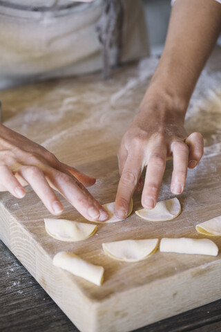 Frau bereitet Ravioli auf einem Backbrett zu, lizenzfreies Stockfoto