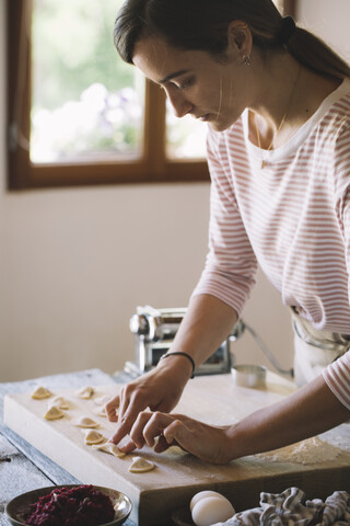 Frau bei der Zubereitung von Ravioli mit Rote-Bete-Salbei-Füllung, lizenzfreies Stockfoto