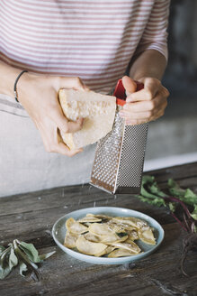 Gefüllte Ravioli auf Teller, Käsereibe - ALBF00514