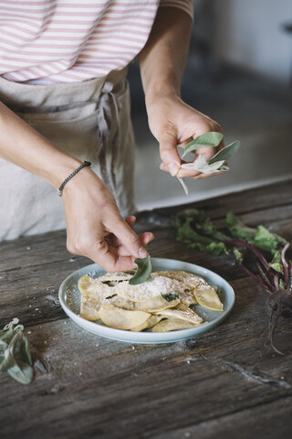 Filled ravioli on plate, sage stock photo