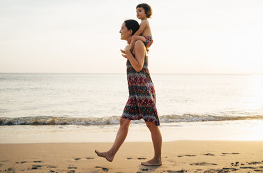 Thailand, Krabi, Koh Lanta, Mutter mit kleiner Tochter auf den Schultern am Strand bei Sonnenuntergang - GEMF02079
