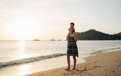 Thailand, Krabi, Koh Lanta, Mother with little daughter on her shoulders on the beach at sunset - GEMF02080