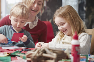 Mother and two children crafting at kitchen table - CUF32443