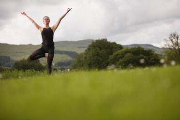 Ältere Frau übt Yoga-Baumhaltung im Feld - CUF32626