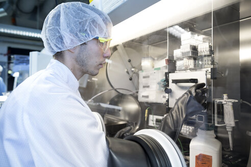 Männlicher Wissenschaftler beim Einstellen des Schalters im Abzug im Laborreinraum - CUF32674