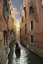 Silhouetted gondolier on narrow canal, Venice, Veneto, Italy - CUF32771