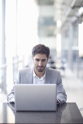 Young businessman using laptop in conference centre - CUF32812