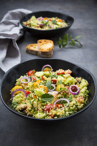 Tabbouleh aus Couscous, Tomaten, roten Zwiebeln, Gurken, Petersilie und Minze, lizenzfreies Stockfoto