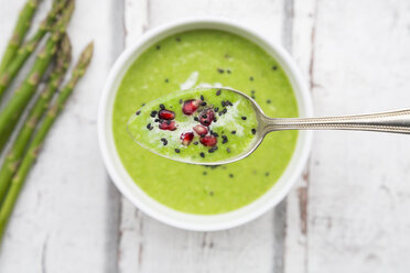 Grüne Spargelsuppe mit Granatapfelkernen und schwarzem Sesam auf Löffel, Nahaufnahme - LVF07114