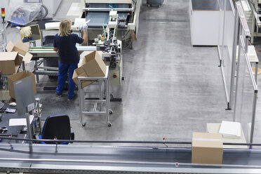 Reife Frau arbeitet in einer Papierverpackungsfabrik - CUF32884