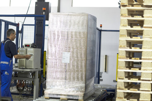 Arbeiter an einer Maschine in einer Papierverpackungsfabrik - CUF32888