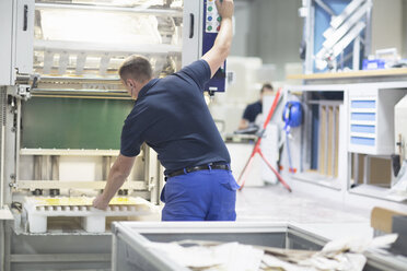 Arbeiter an einer Maschine in einer Papierverpackungsfabrik - CUF32890