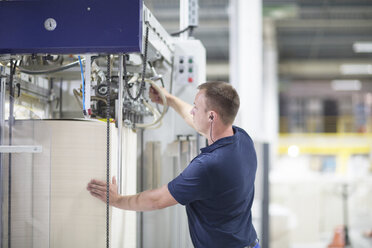 Arbeiter an einer Maschine in einer Papierverpackungsfabrik - CUF32891