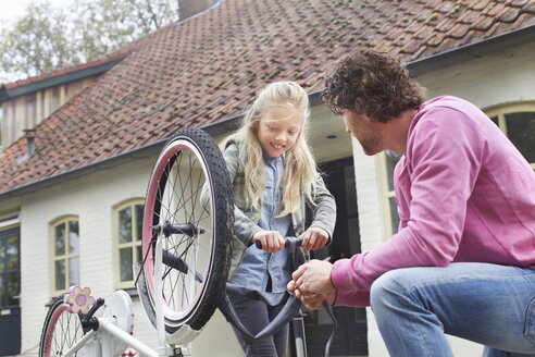 Vater und Tochter flicken Fahrrad - CUF32897