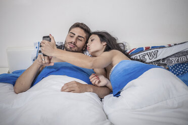 Junges Paar macht Smartphone-Selfie im Bett - CUF32967