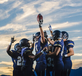 Teenager und junge männliche American-Football-Mannschaft beim gemeinsamen Feiern - ISF10447