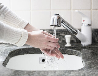 Abgeschnittene Aufnahme einer jungen Frau beim Händewaschen im Waschbecken - CUF33005